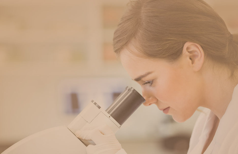 Frau arbeitet mit Mikroskop